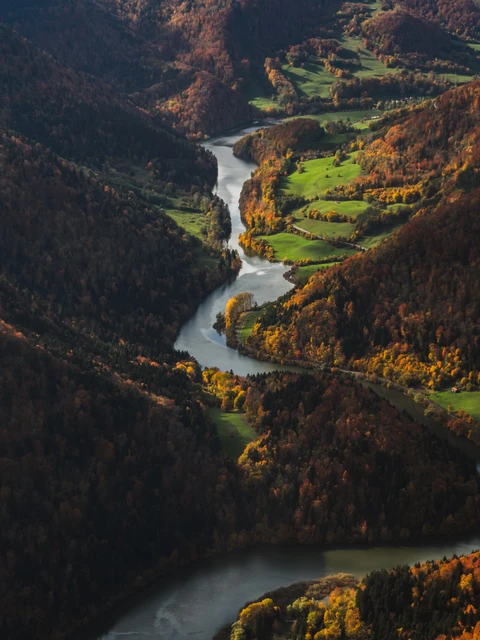 Ein Fluss fliesst durch eine hügelige Landschaft.