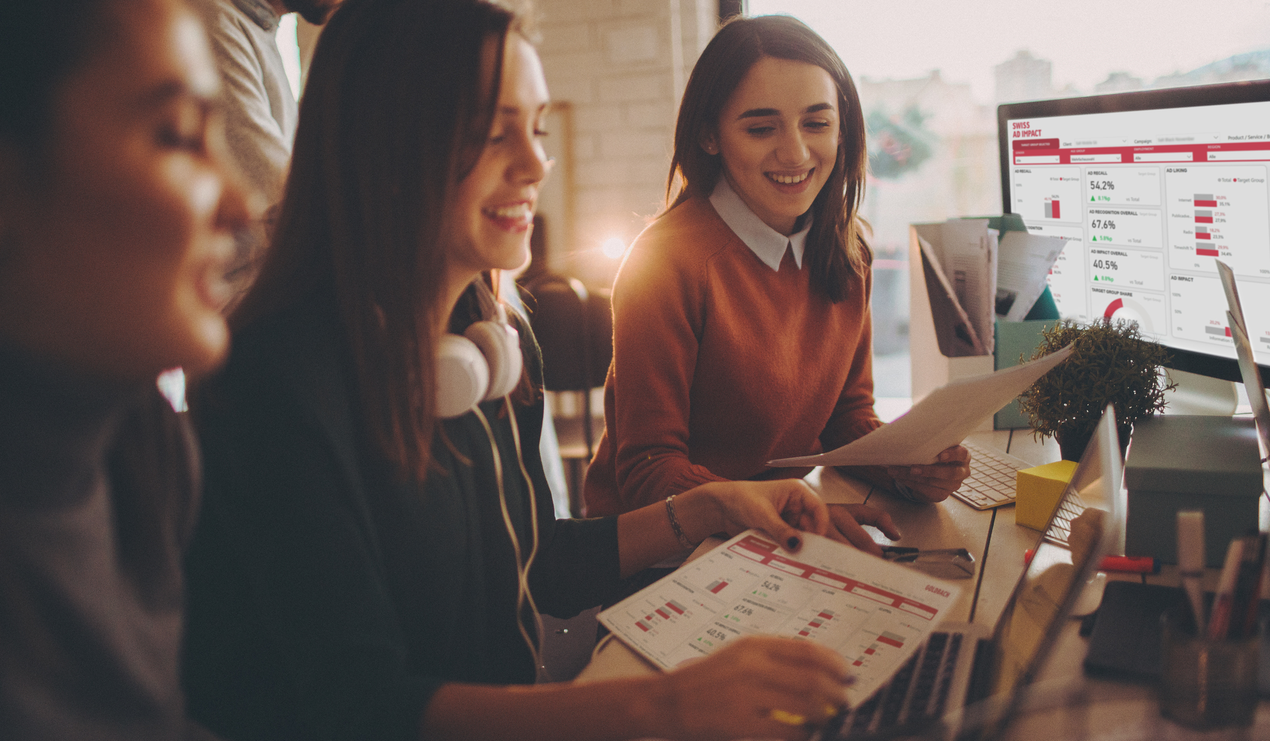 3 junge Frauen sitzen vor Swiss Ad Impact Studie am Screen